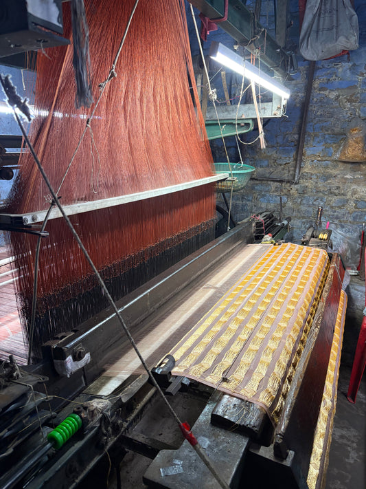 Traditional Banarasi powerloom weaving machine producing zari fabric in a Banaras weaving workshop