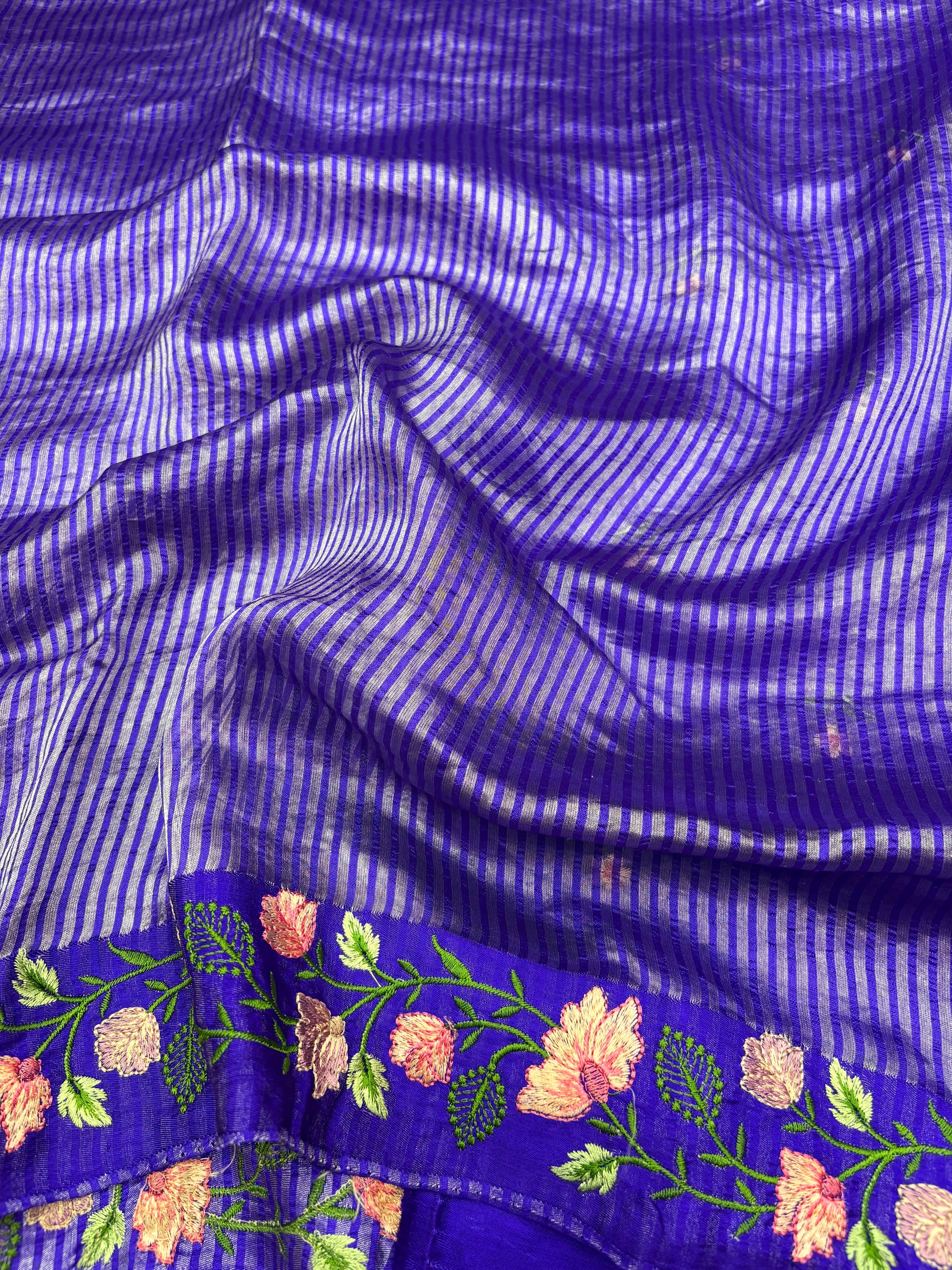 Close-up of a blue fabric with floral embroidery