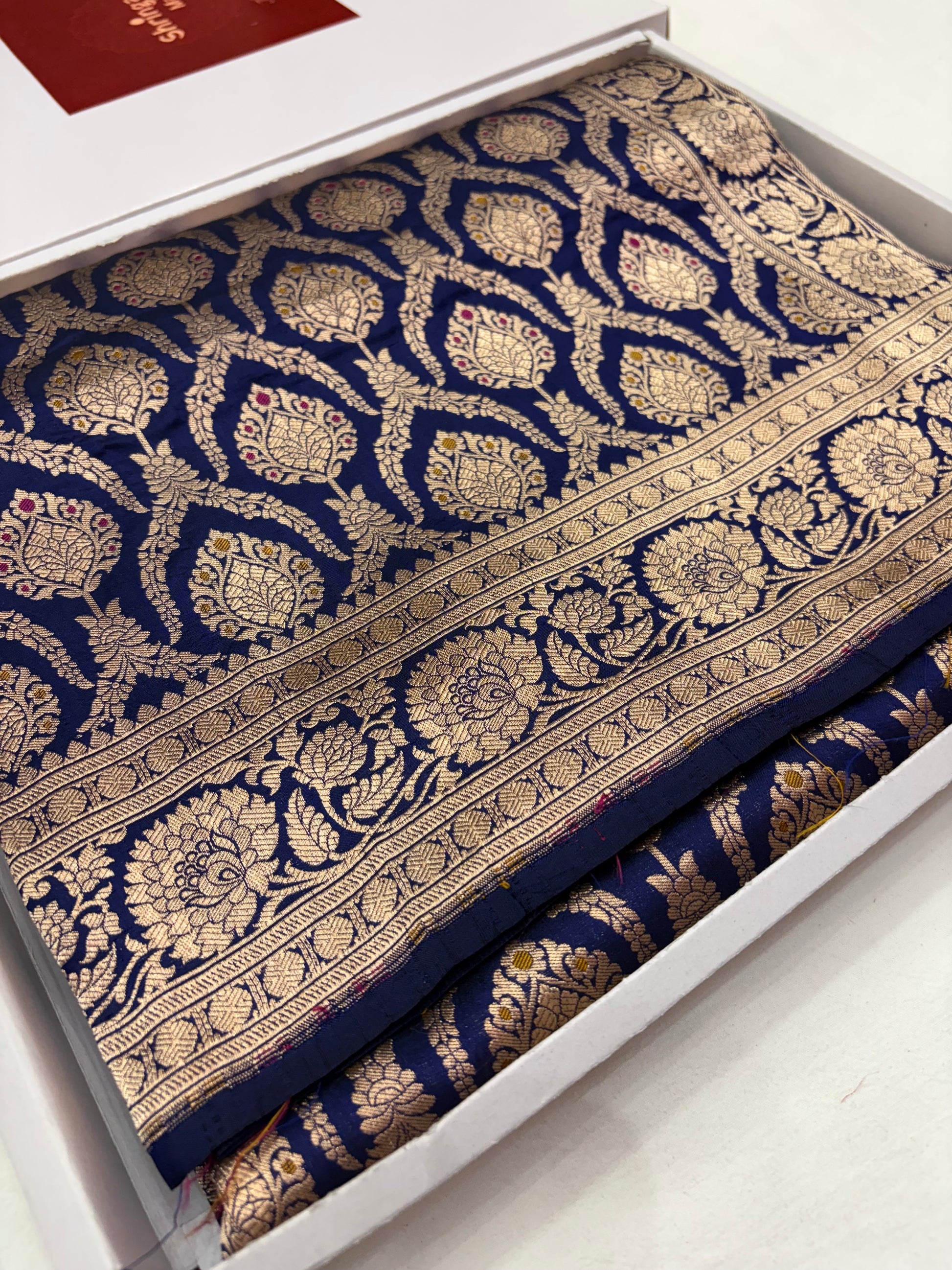 Decorative fabric with intricate gold patterns on a blue background