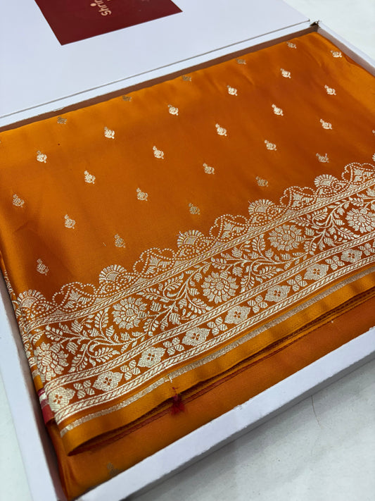 Orange fabric with gold embroidery on a white background