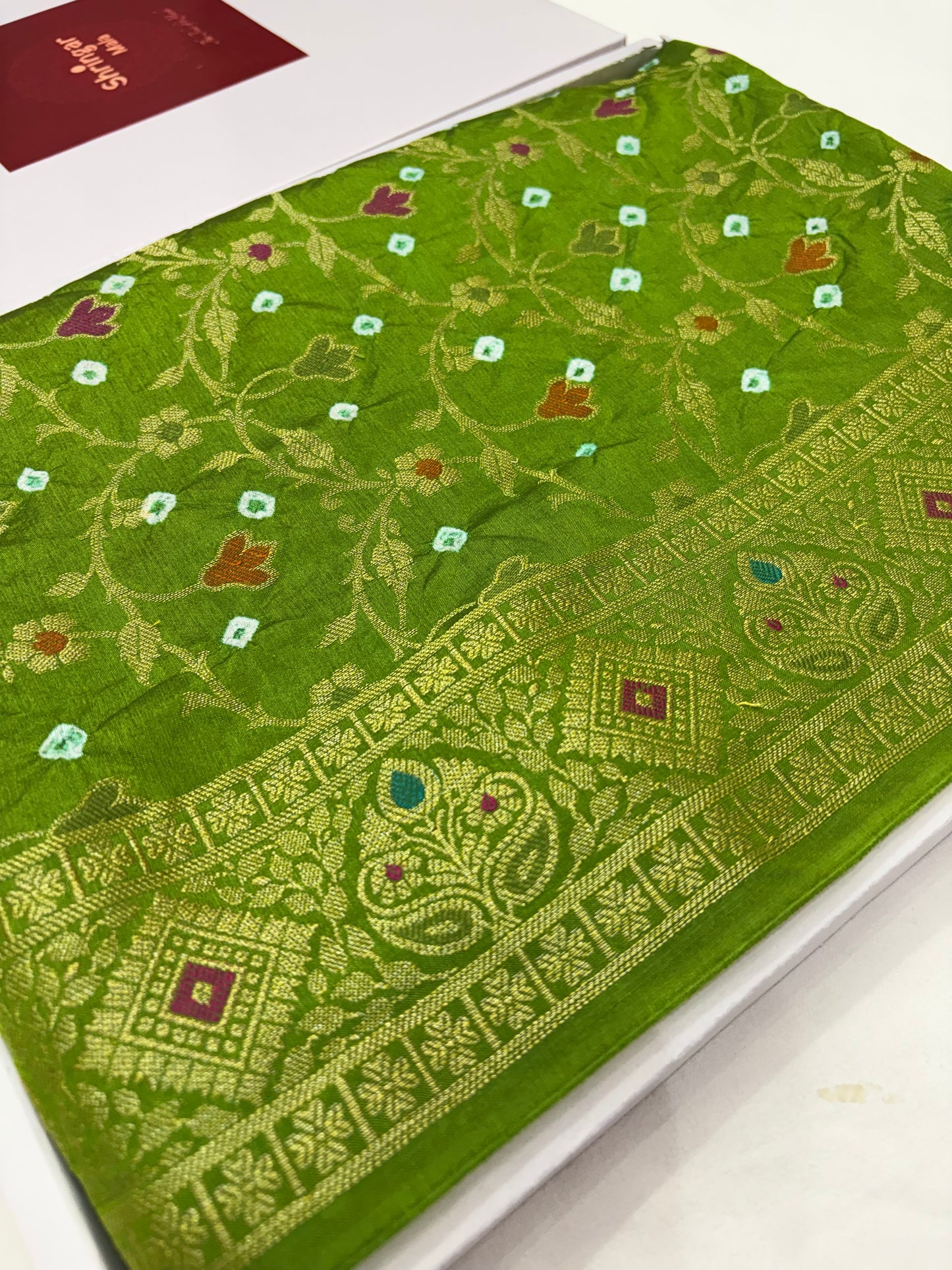Green fabric with intricate gold patterns 