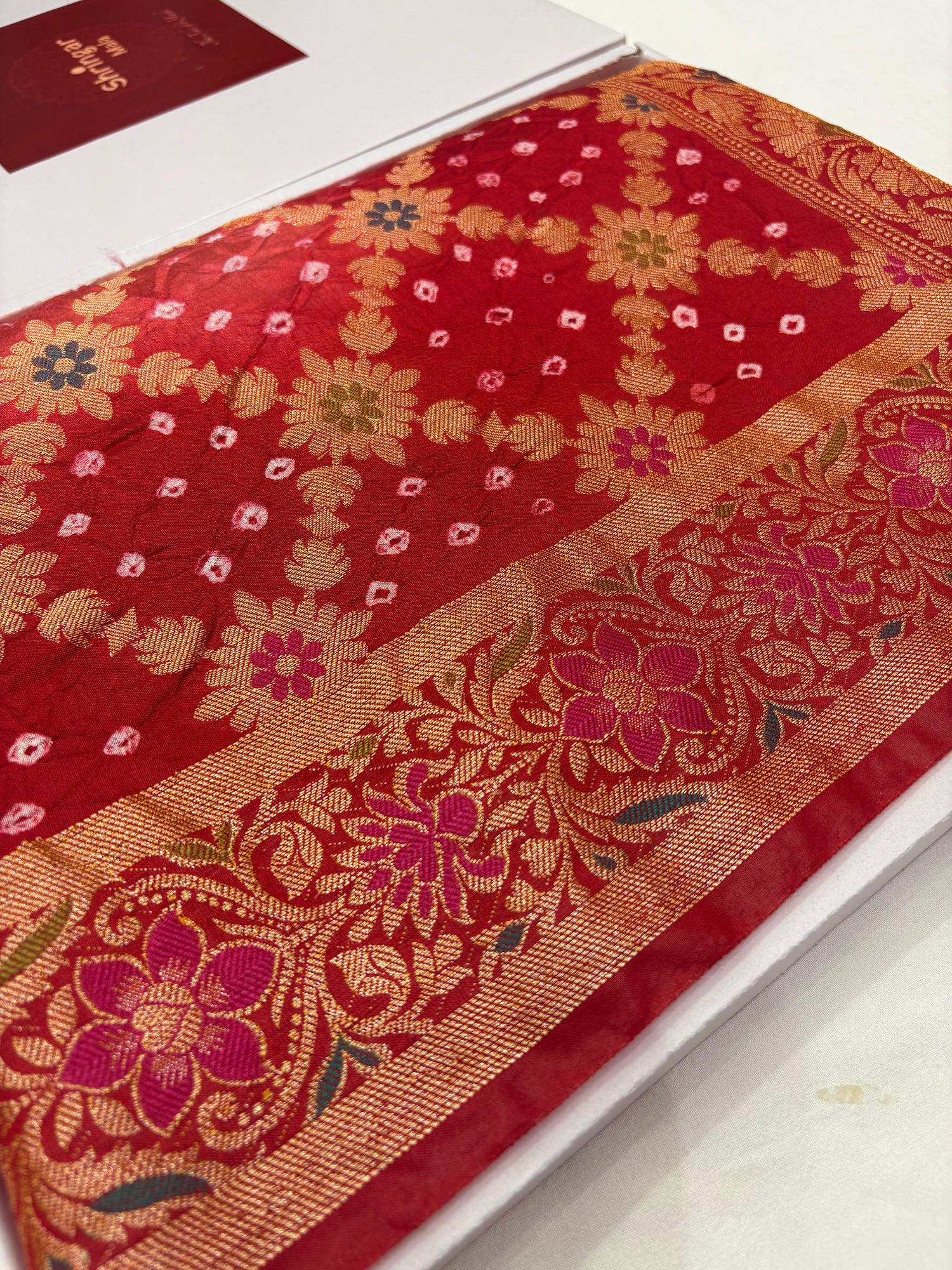 Red fabric with intricate floral patterns on a white background
