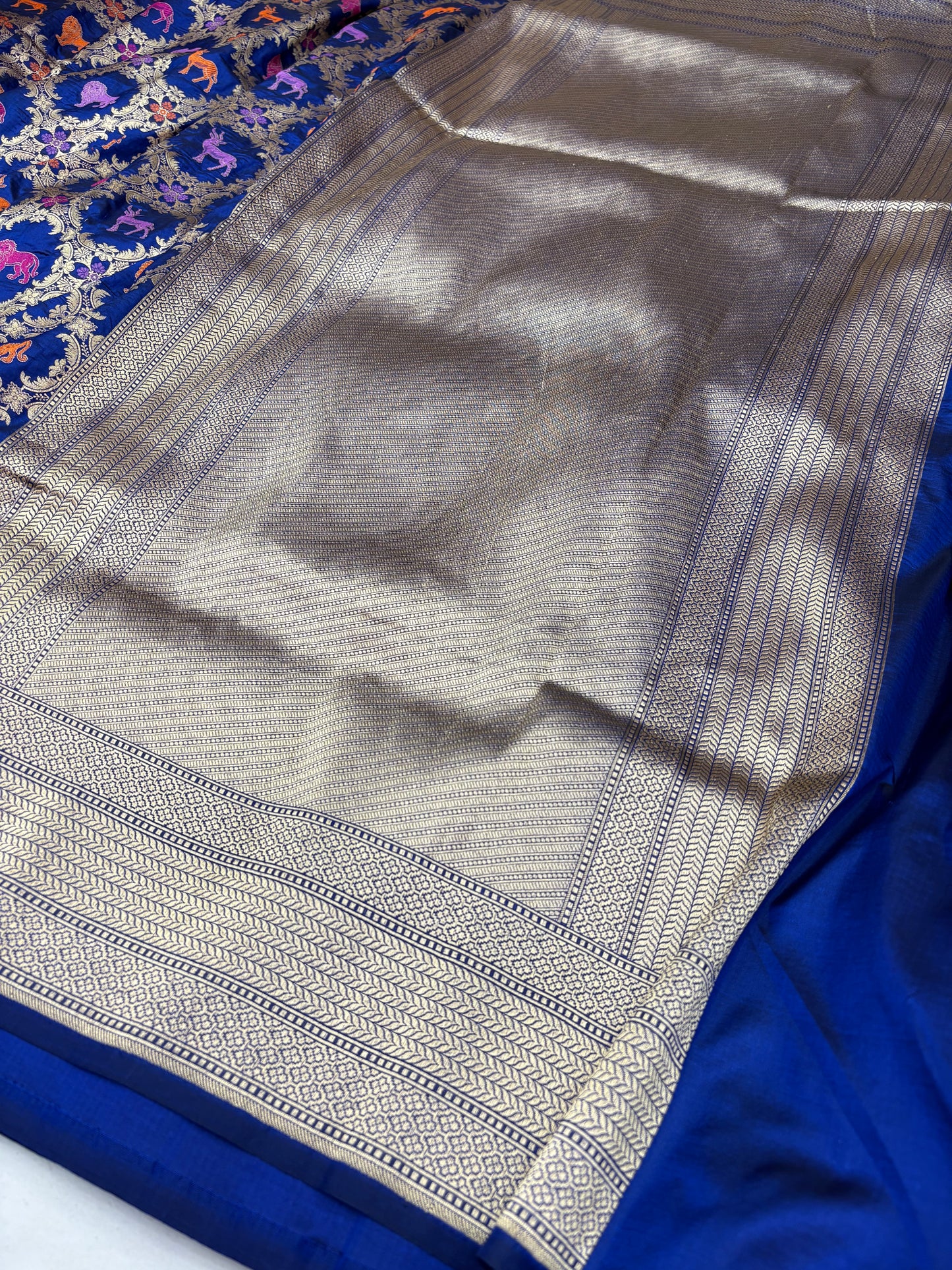 Close-up of a blue and silver saree with intricate patterns