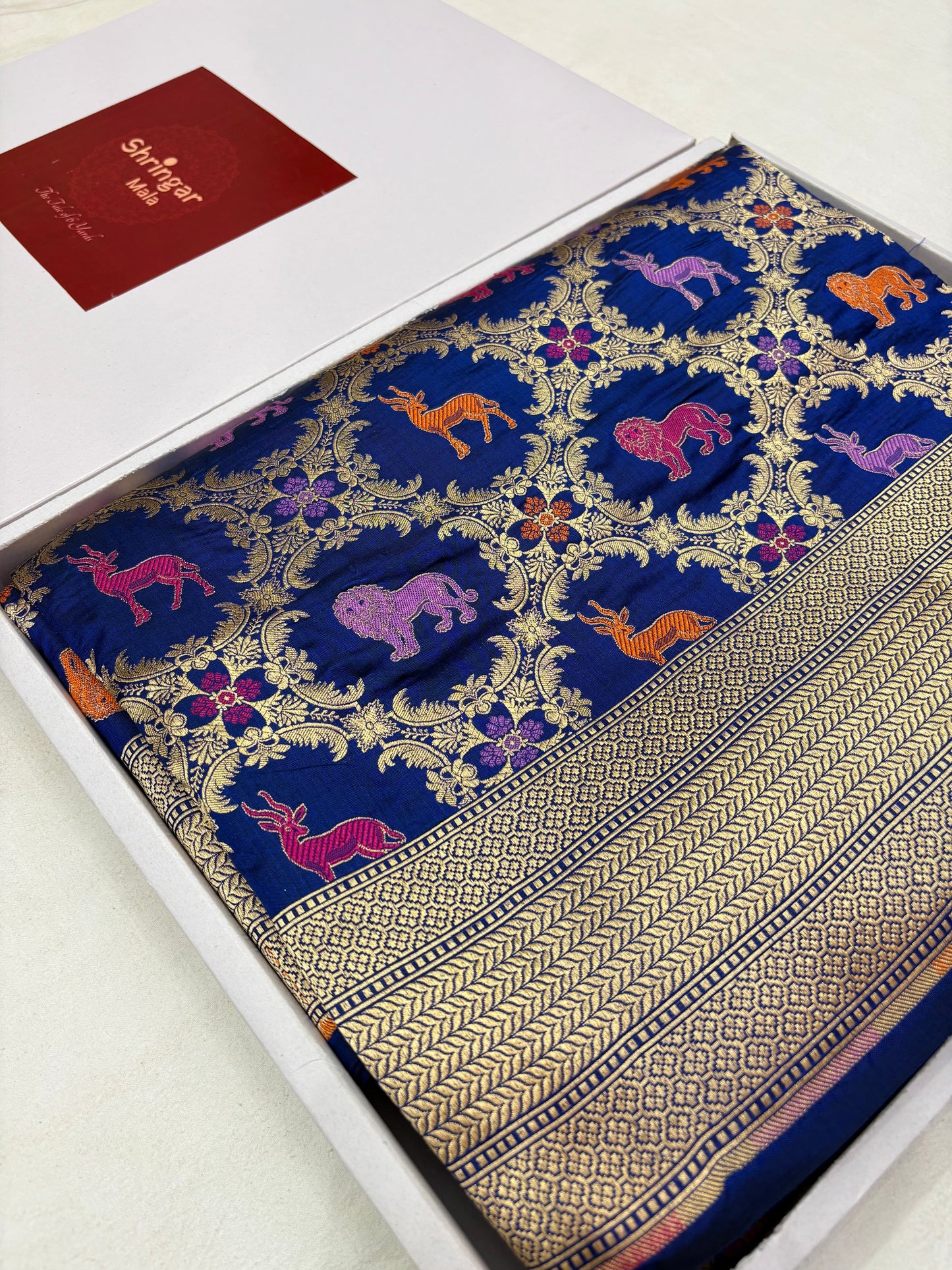 Decorative fabric with intricate patterns in a box, featuring a brand label.