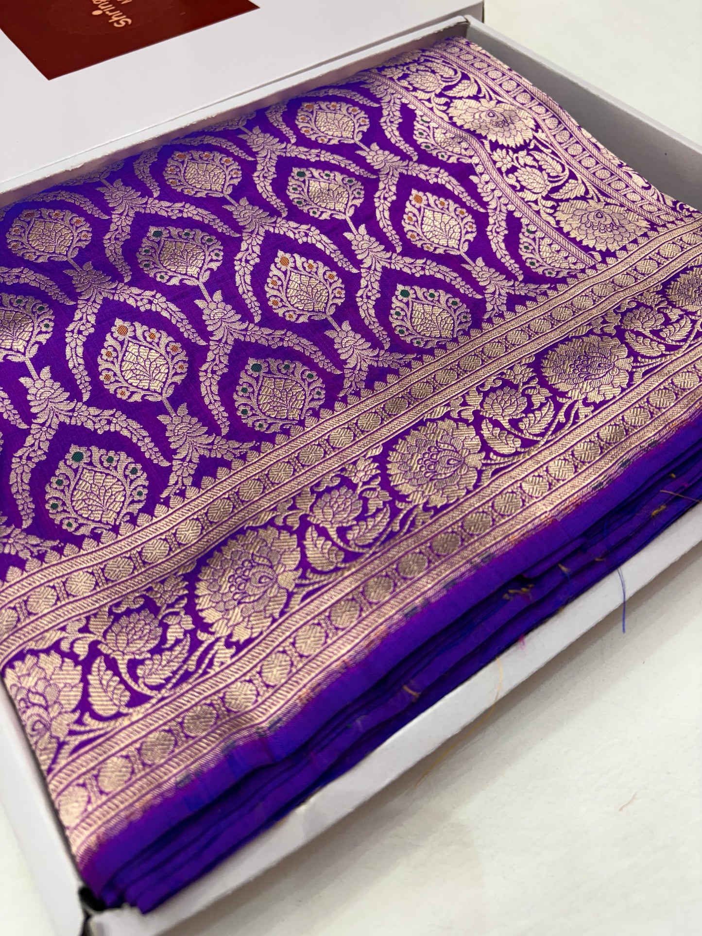 Purple fabric with gold patterns on a white background